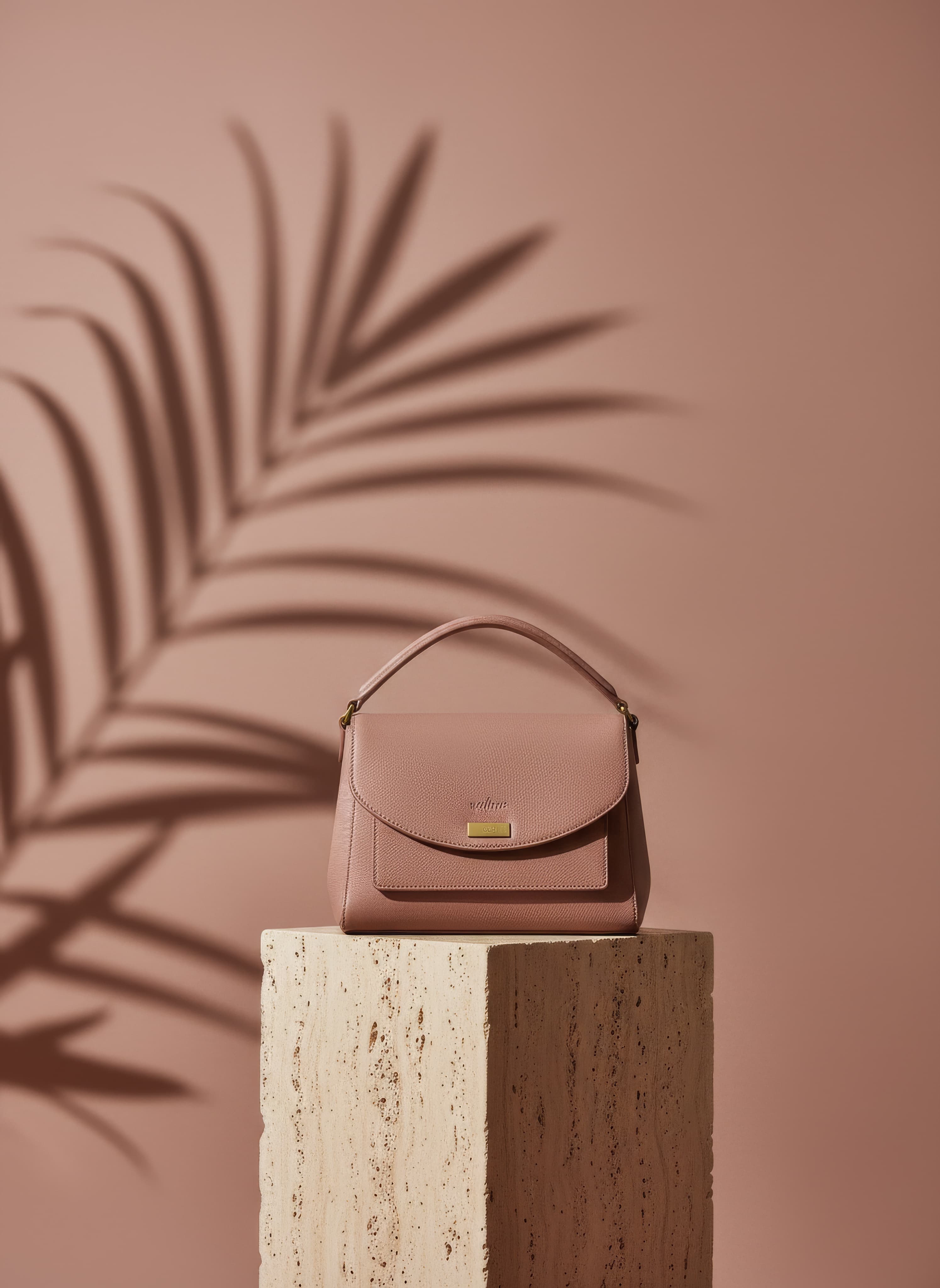 A product photo: a leather handbag on a stone plinth